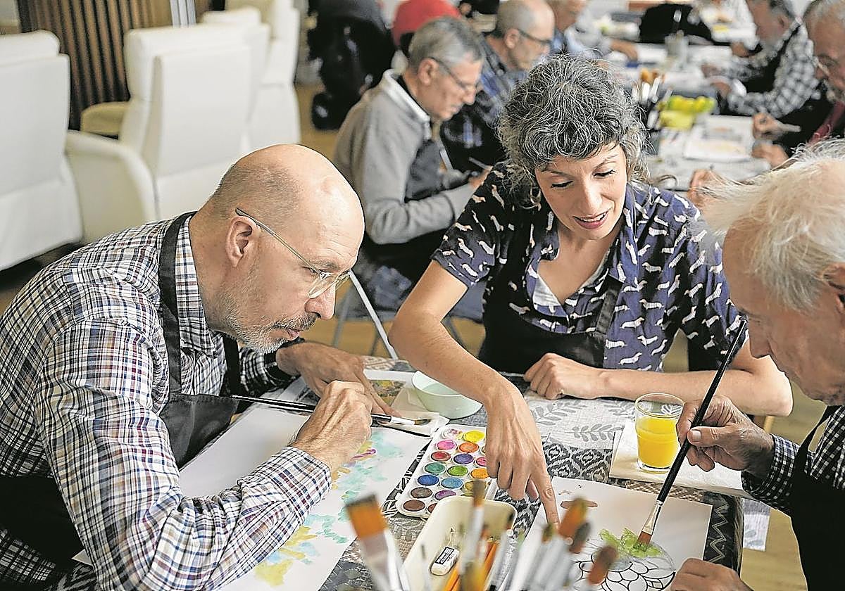 La arteterapeuta Evelyn Pelayo, durante una sesión junto a varios usuarios del centro de Asparbi para personas con párkinson avanzado.