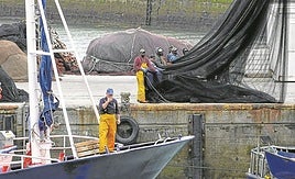 Un pesquero atraca en el puerto de Ondarroa mientras la tripulación prepara las redes.