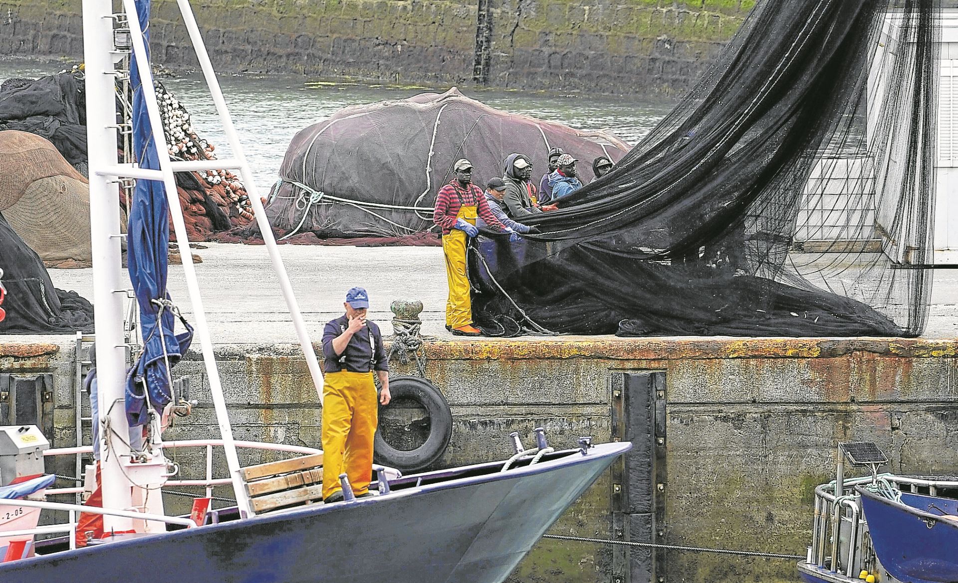 Un pesquero atraca en el puerto de Ondarroa mientras la tripulación prepara las redes.