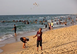 Un niño jugando con la arena este viernes junto al resto de palestinos desplazados que nadan en el mar Mediterráneo a orillas de Khan Yunis, al sur de la Franja de Gaza.
