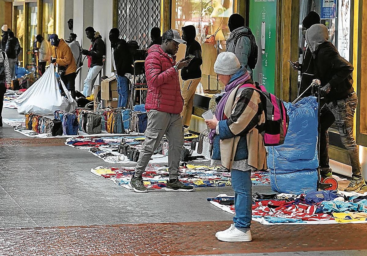 Manteros exhiben sus productos en una calle de Bilbao
