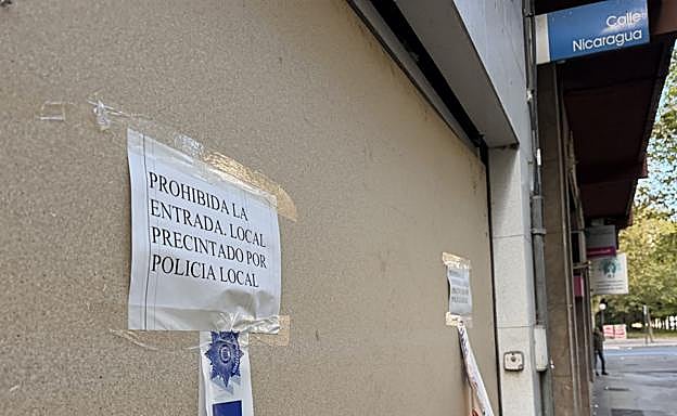 Carteles de aviso en los paneles que cubren el acceso a la lonja.