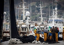 Varios pescadores reparan las redes en el puerto de Pasaia.