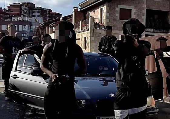 Supuestos componentes de la banda 015 posan una calle del barrio de Ali con un coche de alta gama.