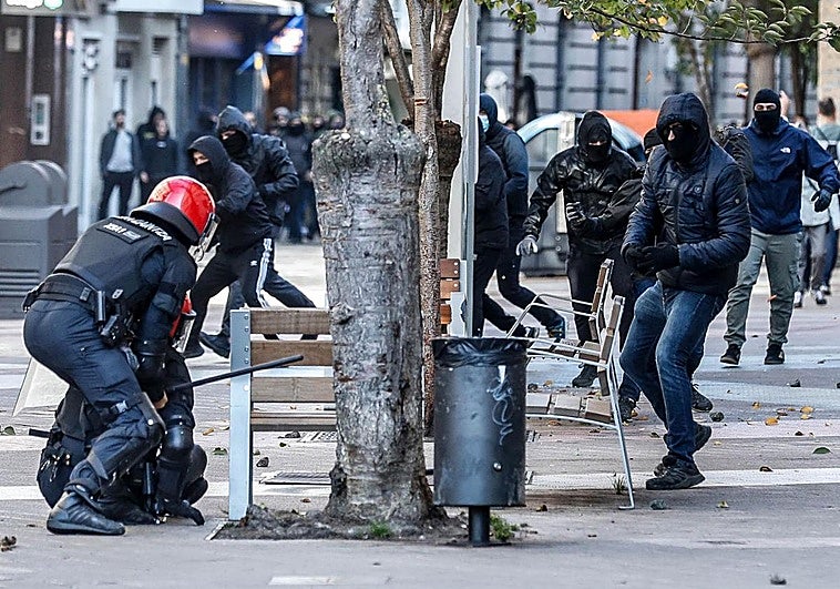 Un ertzaina auxilia a un compañero tras ser agredido por los radicales.