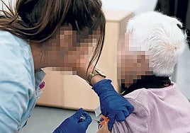 Una sanitaria de Osakidetza vacuna a una persona mayor.
