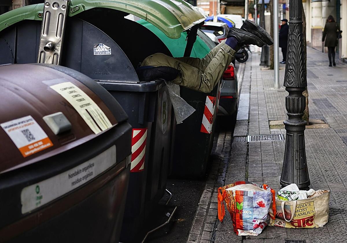Una persona busca en un contenedor en Bilbao.