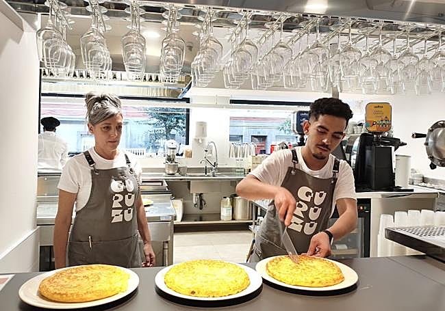 Zuriñe Pérez observa a Choauaib Ouaziz mientras dispone unas tortillas en la barra.