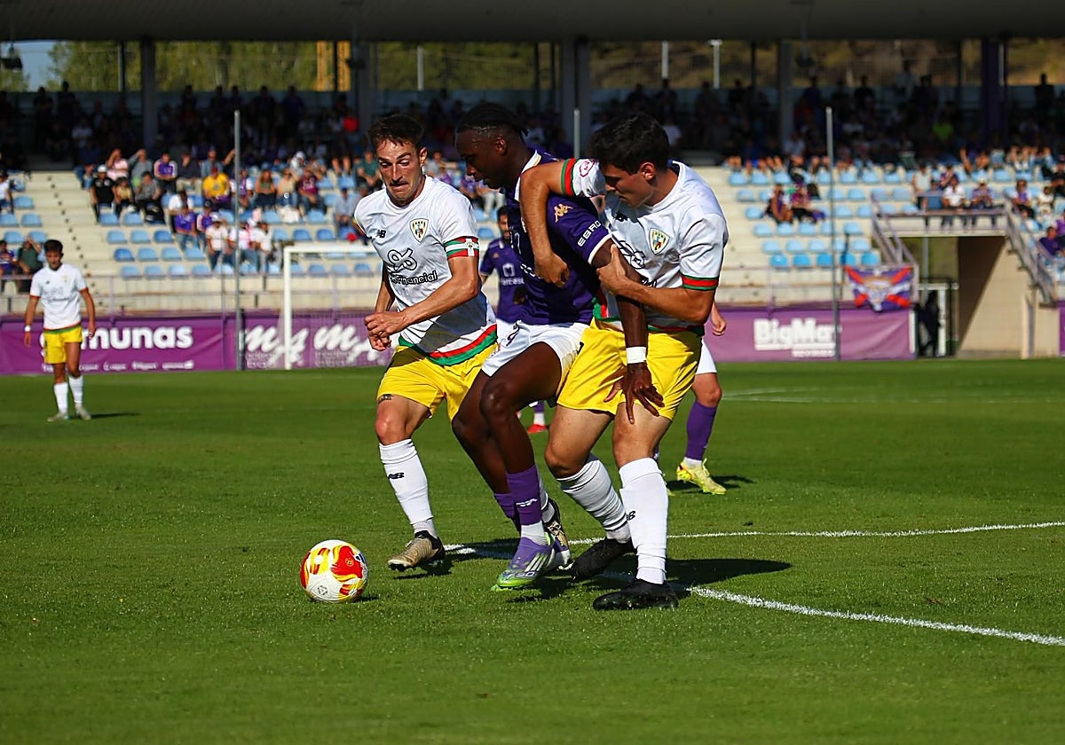 Markel Arana y Julen Huidobro tratan de robar un balón a Salifo.