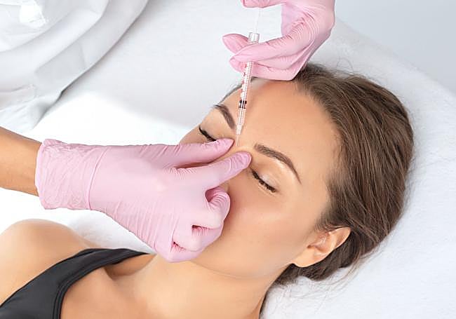 Una mujer se somete a un pinchazo de bótox en el entrecejo.