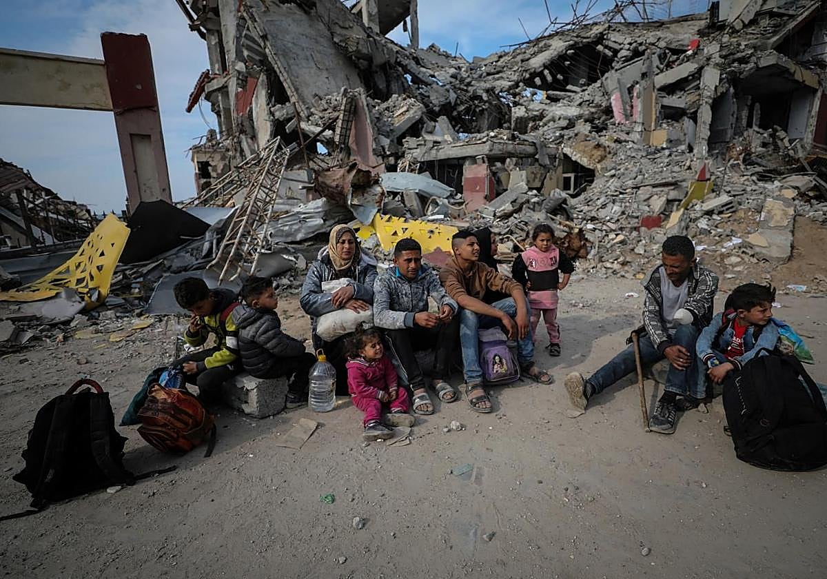 Ismael Mohammed, de 47 años, y su familia, que fueron desplazados a la parte sur de Gaza por orden de Israel durante la guerra, descansan en la carretera mientras regresan a su casa destruida en medio de un alto el fuego entre Israel y Hamás, en Ciudad de Gaza.