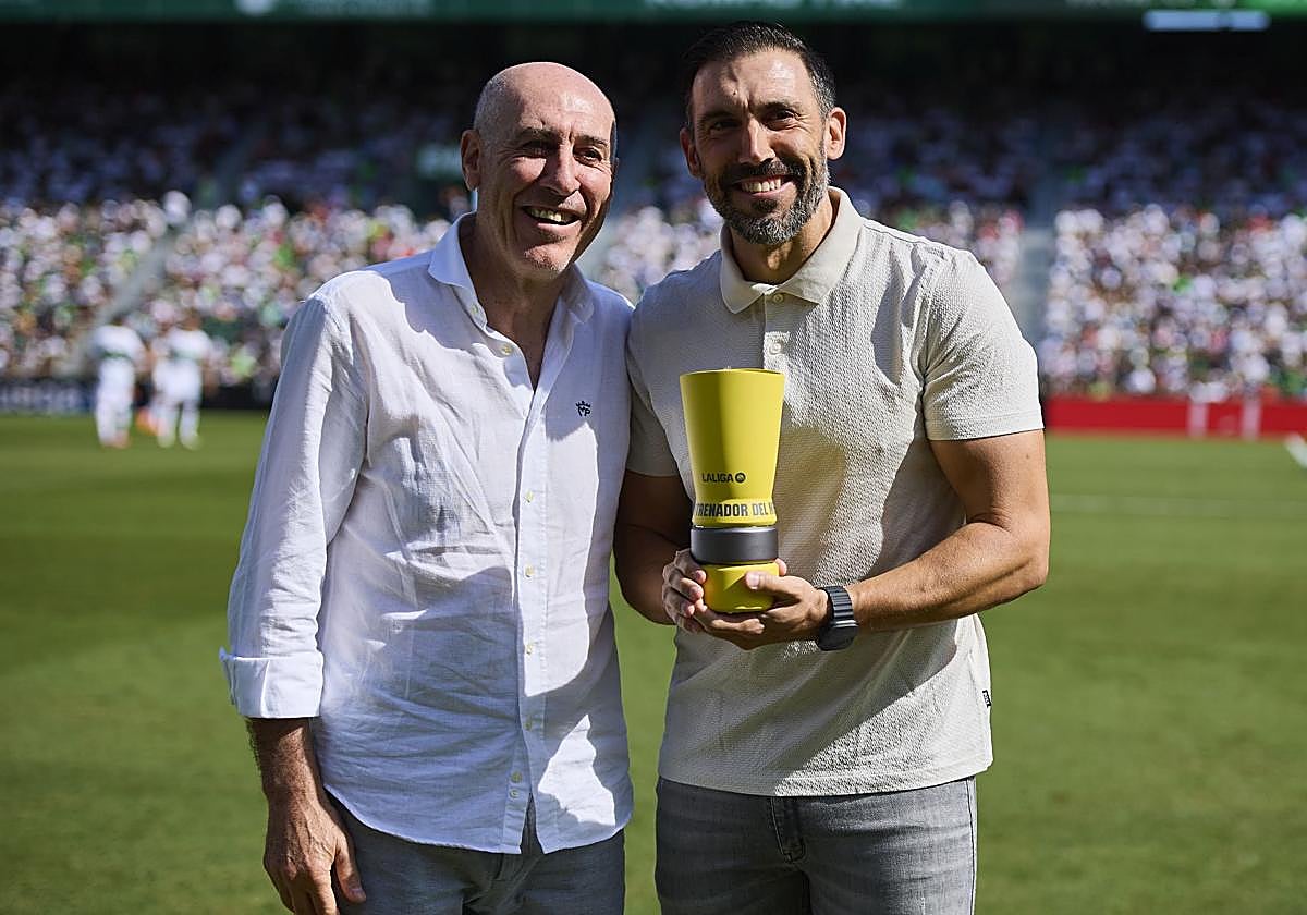 Manolo Sarabia le entrega a su hijo, Eder Sarabia, el premio a Mejor Entrenador del mes de septiembre.