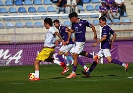 Eric Pérez da un pase mientras le persiguen varios jugadores del CD Guadalajara.