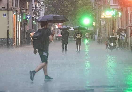 Un joven se cubre con un paraguas en Vitoria.