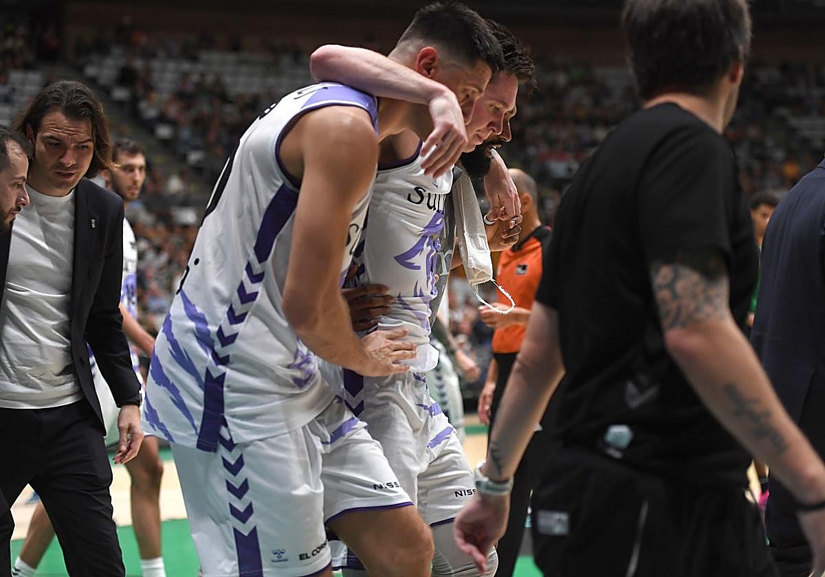 Krampelj y Hilliard ayudan a Jaworski a salir de la cancha en Badalona.