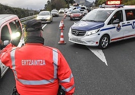 Un agente de la Ertzaintza ajeno a la información regula el tráfico.