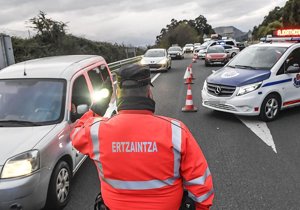 Un agente de la Ertzaintza ajeno a la información regula el tráfico.