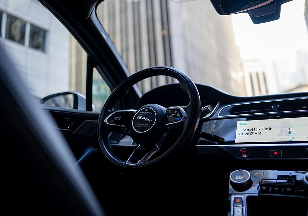 Imagen secundaria 1 - Arriba a la izquierda, los sensores y cámaras en la parte superior del robotaxi; a la derecha, el coche circula sin volante y, abajo, la aplicación móvil avisa del tiempo de espera para la recogida.