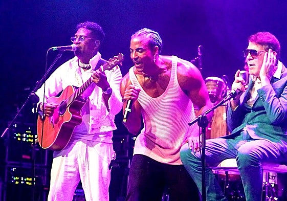 Yotuel con camisa de tirantes y Roldán con traje verde.