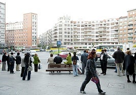 Pasajeros esperan al autobús en la plaza Zabalburu.
