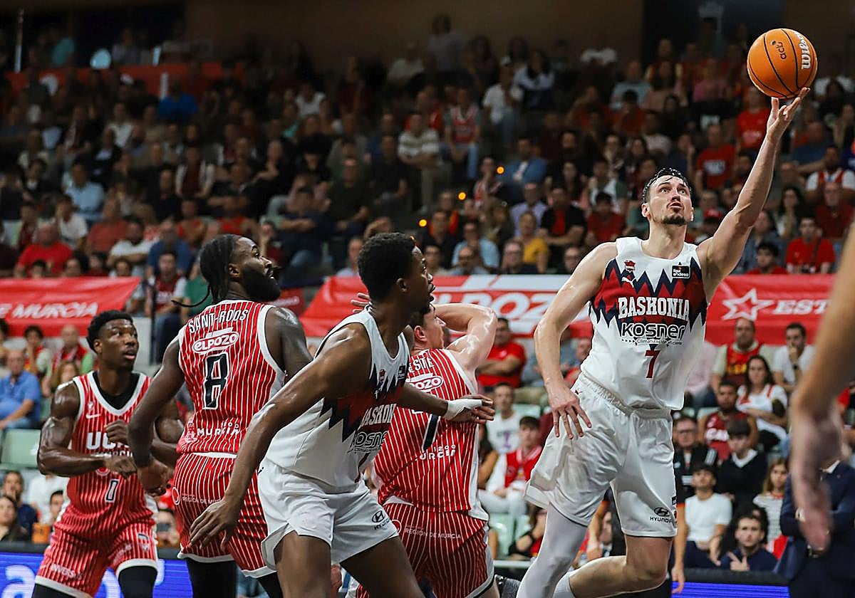 Rodions Kurucs culmina una bandeja con la mano izquierda ante la mirada de Diakite.