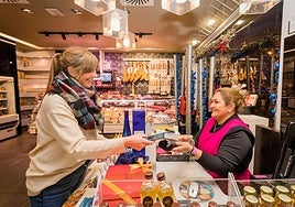 Una clienta abona su compra en Delicatessen La Blanca, en Zabalgana.