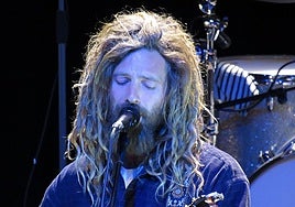 Con trenzas rastafaris y barba new age.