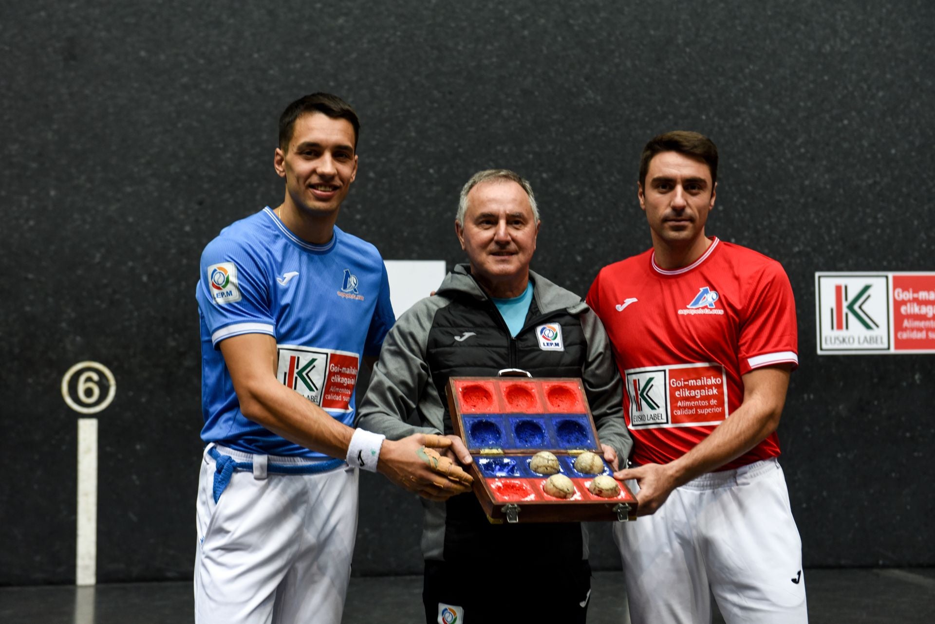 Los dos pelotaris protagonistas junto al seleccionador de material, Martín Alustiza, con las pelotas escogidas