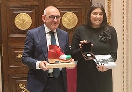 Ramiro González, diputado general junto a Mónica Calvo, presidenta del Centro Gallego, posan con los objetos intercambiados durante el acto.