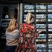 Dos mujeres observan los precios de una inmobiliaria en Bilbao.