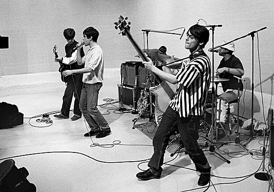 'Mani' Mounfield, en primer plano con el bajo, durante una actuación de Stone Roses a finales de los 80.