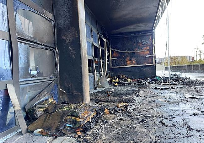 Restos de colchones, enseres y parte de la fachada quemada.