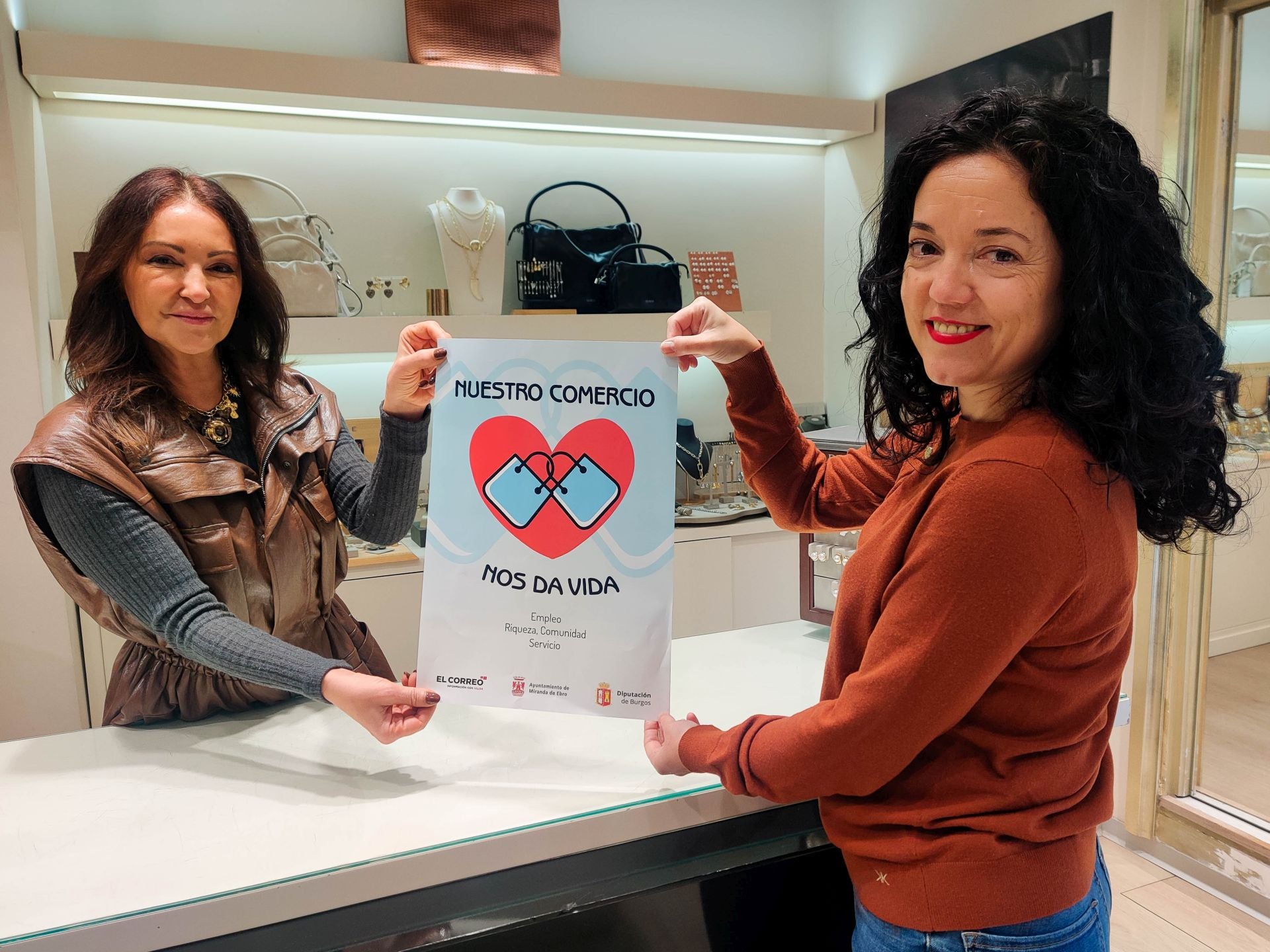 Imagen secundaria 2 - Jorge Castro, el diputado provincial, con el responsable de Carnicería Mariló, Miguel Ángel Adrián, concejal de Promoción Económica, en Resines; y otro cartel más con corazón en Amelia Complementos.