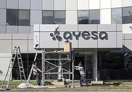 Trabajadores colocando el logo de Ayesa después de que adquiriera la antigua Ibermática en 2022