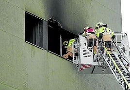 Varios bomberos accediendo a la vivienda siniestrada horas después de sofocar las llamas.
