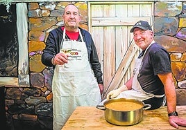 Alberto Gómez García y Carlos Alonso posan frente al mural pintado a mano que representa los pozos del Valle Salado.