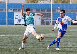 El albiazul Lander Pinillos se estira para tocar un balón en presencia del un adversario.