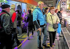 Clientes del Mercado de la Ribera ojean un puesto de pescadería.