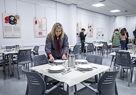 Una encargada del Bizan coloca los platos en una mesa.