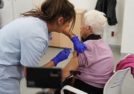 Una mujer recibe una dosis de la vacuna contra la gripe.