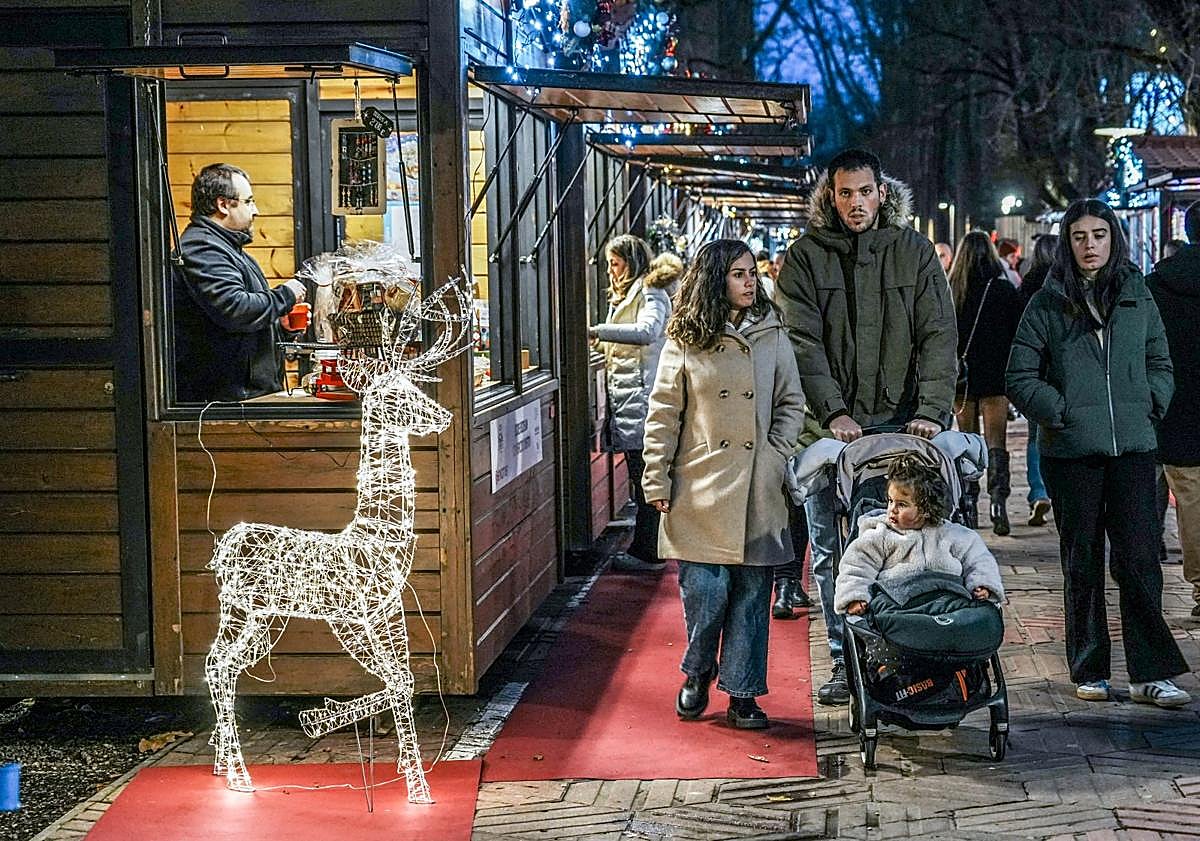 Imagen principal - El Mercado Navideño iluminó La Florida con sus puestos de artesanía y dulces. La visita al pesebre, una de las imprescindibles en el Belén. Reparto devino caliente tras el concierto de la Coral Manuel Iradier.