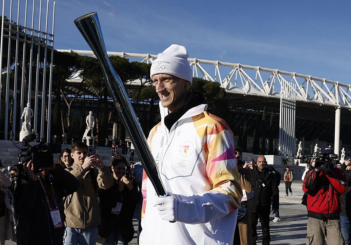 Polonara, sonriente con la antorcha olímpica.