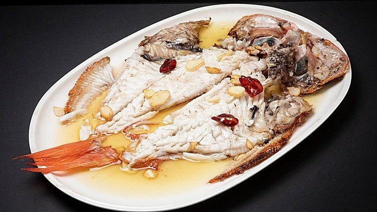 Pescados y chuleta en las brasas de uno de los mejores parrilleros
