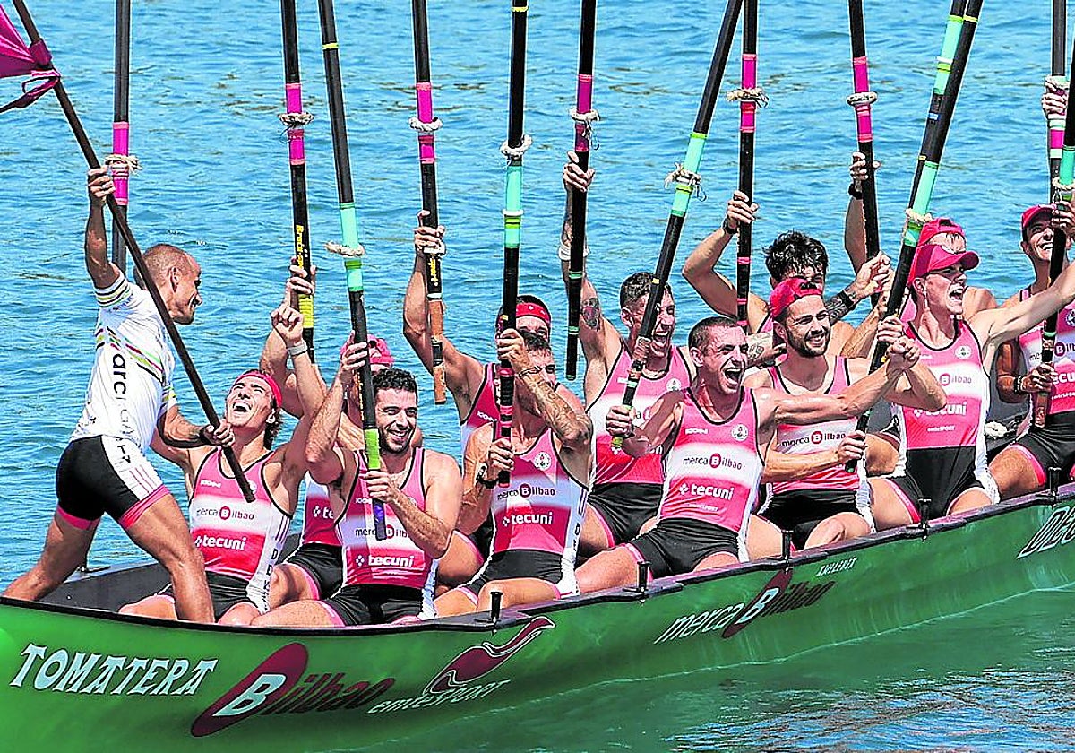 La tripulación de Deusto saluda a la afición con los remos en alto.