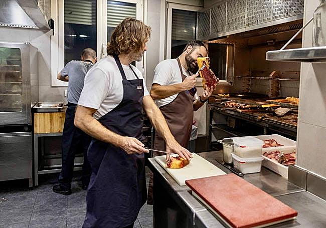 Xabi Gorrotxategi observa el punto de asado junto a su hermano Iñaki.