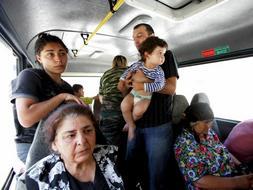 Varios de los nuevos miles de refugiados de Osetia del Sur dejan su ciudad en un autobús. /EFE