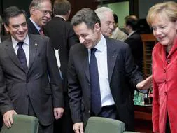 El primer ministro francés, François Fillon (i), el presidente francés y presidente de turno del Consejo de Europa, Nicolas Sarkozy (c), y la canciller alemana, Angela Merkel (d), fotografiados al inicio de la cumbre de la Unión Europea en Bruselas. /Efe