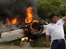 Seguidores del depuesto presidente hondureño, Manuel Zelaya , queman un coche de Policía durante una protesta a las afueras del cementerio de Tegucigalpa (Honduras) ./ Efe