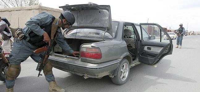 Un agente de la policía afgana inspecciona un vehículo. / Efe