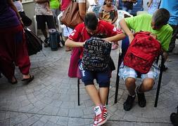 Dos niños revisan el material escolar que les ha entregado el SAT. / Foto: Cristina Quicler (Afp) | Vídeo: Atlas